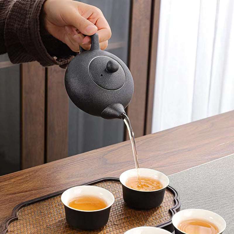 Tea is poured in a black Chinese tea pot