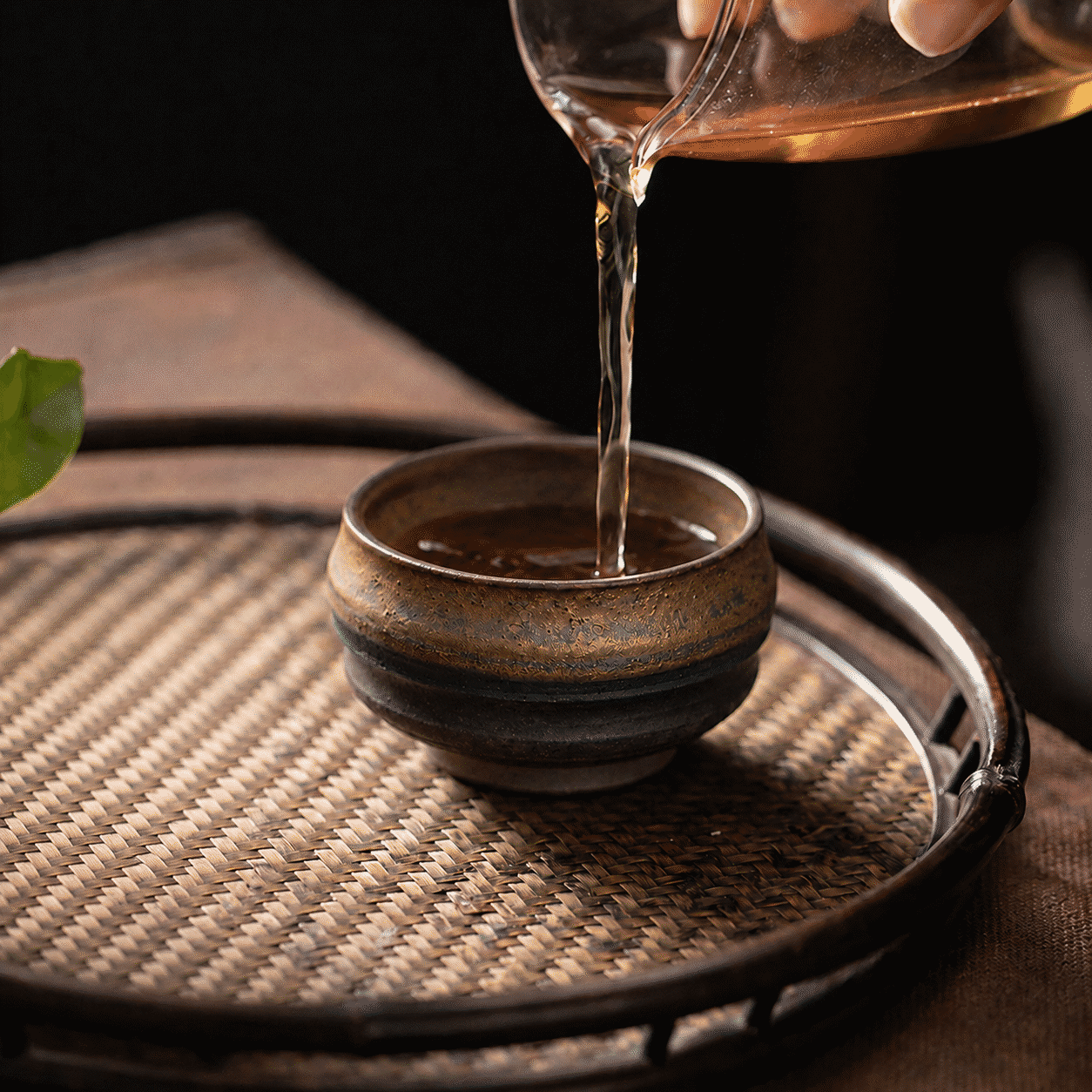 Gongfu tea poured into a gold-tone iron glaze tea cup