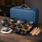 Portable purple clay Chinese tea set with teapot, tea cups, tea tray, and blue travel case